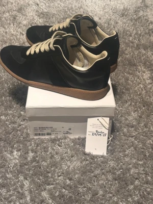 Maison Margiela gats - äkta med box, dustbag samt certifikat - Nu var det dags att sälja mina sjukt snygga Maison Margiela gats då jag tyvärr inte använt dem så mycket som jag hoppats på. Dem är klassiska och extremt enkla att matcha och fungerar lika bra med både jeans men också mer uppklätt. Dessa skor är i toppskick och det ingår även som titeln säger, box, dustbags och certifikat🤗🤗 hör av er vid minsta lilla fundering👍 pris ej hugget i sten👌
