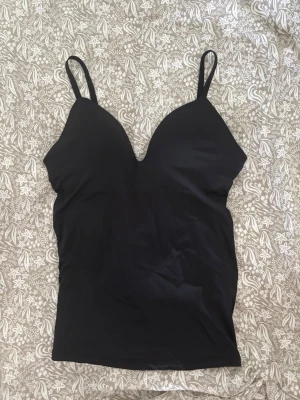 Svart topp med inbyggd push up - Snygg svart linnetopp med push up inbyggd! Väldigt eftertraktad därav priset, liknar HM bodyn!!💕💕