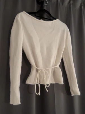 Vit långärmad tröja med knytband - Populär topp som är slutsåld. Köpt för 399kr för två veckor sen. Man kan knyta den fram eller bak.