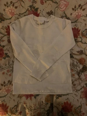 Vit stickad tröja från Vila - Vit basic tröja från Vila. Tröjan är i storlek S. Den har kommit till användning och har därför lite noppror och ett litet hål (bild 4)