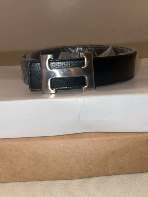 Bälte med H buckle - Helt nytt och snyggt bälte, 110 cm långt. Bra kvalitet och aldrig använt. Har du frågor? Dm gärna 