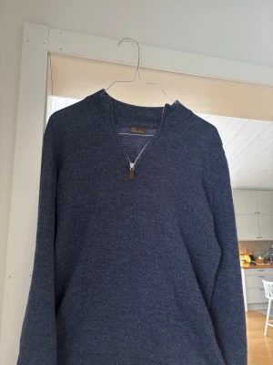 Mörkblå halvzip tröja Stenströms - Mörkblå stickad tröja från Stenströms med halvzip och ribbade detaljer vid halsen. Tröjan har en klassisk passform och är tillverkad i ett mjukt material som passar perfekt till lager på lager. Enkel och stilren design.