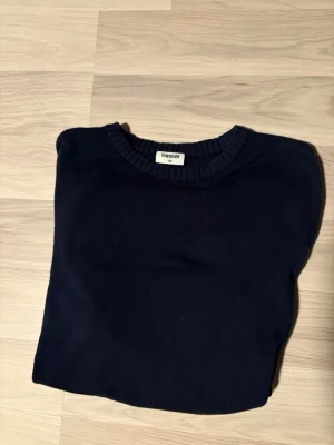 Mörkblå tröja från Kappahl - En stilren mörkblå tröja från Kappahl med rund halsringning. Perfekt för en enkel och clean look. Tröjan är i mjukt material och passar till många olika outfits. Storleken är 170 och är lika som S