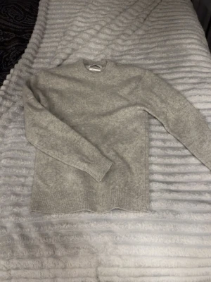 Ljusgrå stickad tröja i merinoull  - Mysig ljusgrå stickad tröja från valient, säljer den åt min kille då den inte längre passar.