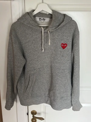 Grå hoodie Comme des Garçons Play - Säljer denna super snygga hoodie från CDG i storlek M. Skriv vid funderingar!