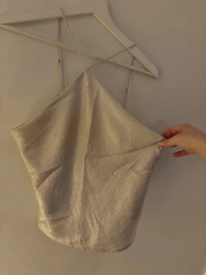 Champagnefärgad linnetopp Gina Tricot - Champagnefärgad linnetopp från Gina Tricot med tunna axelband och lätt glansig yta. Storlek M!