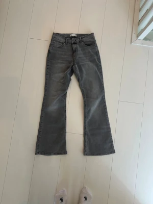 Grå bootcut jeans med fem fickor - Snygga grå jeans med bootcut-modell och klassisk femficksdesign. Jeansen har normal midja och är tillverkade i mjukt denimtyg. Perfekta för dig som gillar en avslappnad men trendig look.