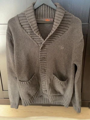 Grå stickad kofta med knappar - Mysig grå stickad kofta från Morris, stora framfickor och knäppning med fyra knappar. Perfekt för lager på lager och chill dagar. Inga defekter och sällan använd! Storlek S. Hör av er för fler frågor/bilder!