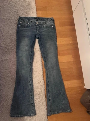 Blå bootcut jeans med låg midja - Säljer ett par blå bootcut jeans från True Religion med låg midja. Jätte snygga och i väldigt fint skick. Storlek 25