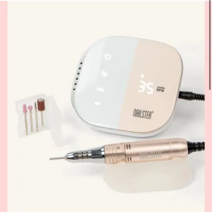 Elektrisk nagelfil från Nailster - Snygg elektrisk nagelfil i metallic roséguld och vitt från Nailster. Kommer med flera olika sliphuvuden för att fila, forma och polera naglarna. Perfekt för dig som vill fixa naglarna hemma med proffsigt resultat. Jag har använt den runt 4 gånger och har bestämt mig för att inte fortsätta. Den är köpt för två månader sedan för priset 1299kr. Mitt pris går att diskutera