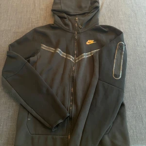 Nike tech tracksuit strl XS - Välvårdad Nike tech svart/grå med några små skavanker. Hoodien är felfri, byxorna har litet märke på knät men inget man märker av. Hör av er om ni har mer frågor