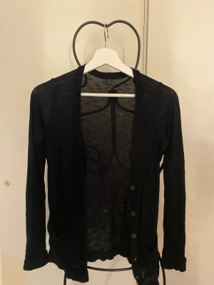 Svart kofta med knappar - Använd ett par gånger och ett litet litet hål i ryggen, men inget som syns. Fint skick utöver det lilla hålet. 