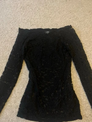 Svart spets offshoulder topp - Snygg svart offshoulder topp i spets med lång ärm. Toppen har en figurnära passform med spetsmönster💕Storlek L men passar bra som M också