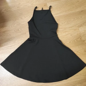 Svart kort klänning med smala band - En svart, enkel och stilren kort klänning med smala axelband.
