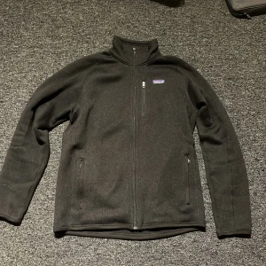 Svart fleecejacka från Patagonia - Säljer en Patagonia Better Sweater i mycket bra skick! Känner att den inte har använts så mycket som jag hade tänkt mig så den tar bara upp plats här hemma. Köpt för ca 1700kr i butik! Priset är inte hugget i sten och går att diskutera!