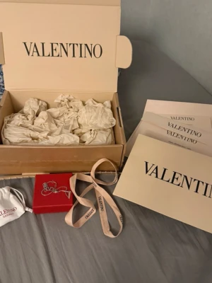 Valentino silverfärgat armband - Snyggt armband från Valentino i silverfärgad metall med ikoniska V-loggor. Kommer med originalförpackning, dustbag och certifikat. Perfekt accessoar för dig som gillar exklusiva detaljer och stilren design. Sälj för de inte andvänds 