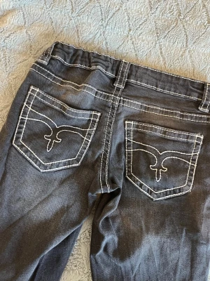 Grå/svarta  jeans med vit kontrastsöm - Snygga jeans från gina tricot, med deckor på fickorna. Benen är utsvängda och i storlek 152. 