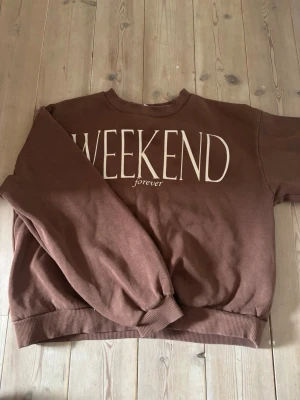 Brun sweatshirt med WEEKEND-tryck - Säljer en brun sweatshirt med texten 'WEEKEND forever' den är knappt använd💕