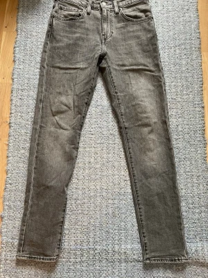 Gråa raka jeans från Weekday - Säljer ett par gråa jeans från Levi’s med rak passform och klassisk femficksdesign. Jeansen har normal midja, bälteshällor och är tillverkade i denim med snygg tvättad look. Perfekta för en avslappnad och trendig stil. 