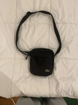 Lacoste axelväska svart - Helt nyskick använd ett par gånger inget mer, skriv vid frågor. 