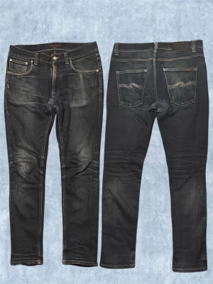 Nudie Jeans skön wash  - Snygga jeans  från Nudie Jeans med klassiska fem fickor och kontrastsömmar. Jeansen har en något tvättad look och smal passform som sitter tight hela vägen ner. Perfekta för en trendig och avslappnad stil.