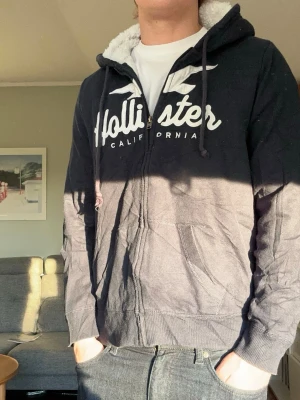 Hollister fur vintage hoodie - En väldigt snygg hoodie från hollister med ”päls” inuti🤩 Jätteskön att ha pondus och pälsen är i bra skick! Storlek L men passar mer som en M, passformen är bra men den är rätt bred nedtill, så passar någon som väger mer än mig😁Är 176cm lång och väger 70kg. Ställ gärna frågor! Mvh