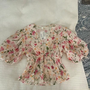 Blommig blus från H&M - Jättesöt blommig blus med puffärmar från H&M! Helt ny med prislapp kvar, oanvänd❣️
