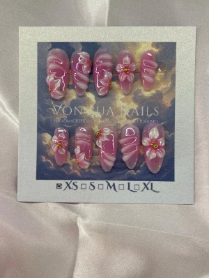 Serafina (XS);Medium Almond - Snygga handgjorda press-on naglar i rosa med glansig finish, swirl-mönster och 3D-blommor med gulddetaljer. Naglarna har en medium lång almondform och är handgjorda i XS: 14 mm, 11 mm, 11,5 mm, 10 mm, 8 mm . Perfekt för dig som vill ha en unik och trendig look.