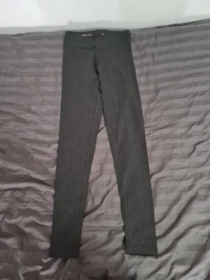 Mörkgrå leggings från Basic You - Mörkgrå leggings från Basic You i mjuk och stretchig ekologisk bomull. De har en klassisk, tight passform med hög midja och är perfekta för en avslappnad och stilren look. Enkla att matcha med både oversized tröjor och crop tops.