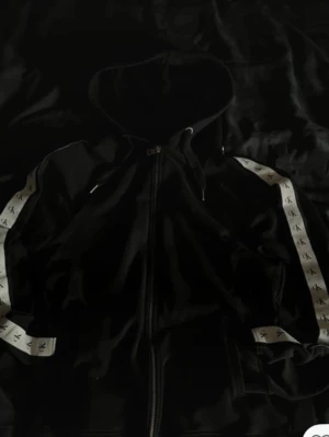 Svart hoodie från Calvin Klein Jeans - Svart hoodie från Calvin Klein Jeans med dragkedja framtill och metallzipper med logga. Tillverkad i mjukt material som känns skönt mot huden. Perfekt för dig som gillar stilrena och klassiska plagg med en modern touch.