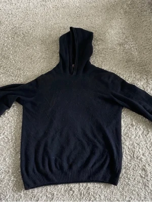 Oscar Jacobson Hoodie - En Kashmir hoodie från Oscar Jacobson. Storlek S. Färg mörkblå. Rätt bra skick, finns ett litet hål i vänster armhåla (hör av dig vid bild). Hör av dig vid minsta lilla fråga eller fler bilder.
