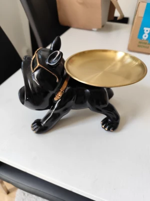 Svart bulldog fat i guld och svart - Cool bulldog-formad skål i svart och guld, perfekt som nyckelfat eller för småprylar. Hunden har solglasögon och halsband i guld, och fatet på ryggen är metalliskt guld. En snygg och rolig inredningsdetalj i hårdplast och metall.