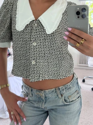 Kort tweedblus med krage - Trendig kort blus i svartvitt tweedmönster med stora vita knappar och en oversized vit krage med volangkant💕💕 Passar även XS/S