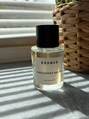 ESSNCE Midsummer Dream parfym - Fräsch parfym från ESSNCE med namnet Midsummer Dream. Flaskan är genomskinlig med en enkel vit etikett och svart lock. Doften är en Eau de Parfum och flaskan har en stilren, modern design i glas. Ny