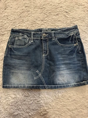 Mörkblå jeanskjol  - Snygg mörkblå jeanskjol från Sublevel med klassiska fickor fram och bak, samt tydliga vita sömmar. I mycket bra skick, storlek S, midjemått= 40 cm, längd = 34 cm