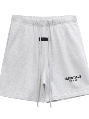 Grå Essentials Fear of God shorts - Snygga ljusgrå shorts från Fear of God Essentials med svart logga på vänster ben. De har elastisk midja med snörning och är tillverkade i mjuk bomull, perfekta för en avslappnad stil. Klassisk passform och stilren design.