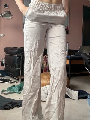 Beiga vida byxor med resårmidja - Säljer ett par byxor med vida ben från H&M. Dem är gjorda i ett tunt, mjukt material som känns skönt mot huden. Perfekta för en sommaren! Buda gärna priser!