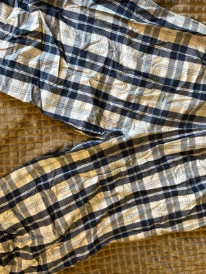 Rutiga blåvita shorts med resår - Säljer ett par rutiga shorts i blått och vitt med resår i midjan. De är tillverkade i mjuk bomull och har en avslappnad passform, perfekta för varma dagar. Klassisk rutig design som ger en chill vibe.