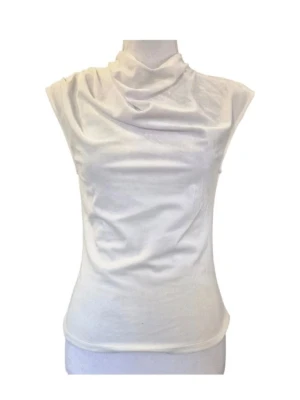Topp i sammet i storlek XS. Nypris 259 kr - Topp TT Irina Velvet i storlek XS. Sammetstyg. Veck en axel. Material 92 % polyester och 8 % elastan. Midjebredd ca 36 cm och längd ca 56 cm. Denna ärmlösa topp har en elegant draperad krage som ger en sofistikerad touch. Toppen är designad för att smickra figuren med sin åtsittande passform och är ett mångsidigt plagg som kan bäras både till vardags och till fest. 840/56