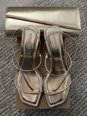 Steve Madden klackskor - Guldiga Steve madden klackar som är använda 1 gång på min bal. De är nästan som nya. Jag har även en matchande väska till om det skulle vilja köpas till🫶🏻🫶🏻ny pris 1350kr