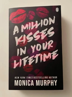 A Million Kisses In Your Lifetime - Säljer boken 'A Million Kisses In Your Lifetime' av Monica Murphy. Omslaget är svart med rosa och röda läppavtryck och vit text. Pocketbok i engelska, romantisk skönlitteratur som passar perfekt för dig som gillar kärlekshistorier. Helt ny skick
