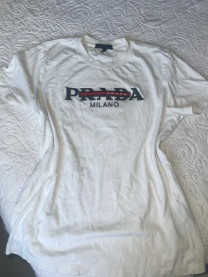 Vit t-shirt - Vit t-shirt från ett känt märke med tryckt logga. Klassisk rund halsringning och korta ärmar. Snygg och enkel design som passar till mycket.