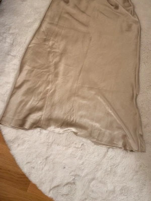 Beige satinkjol - Snygg beige långkjol i satin från Gina Trico. Kjolen är nästan helt ny eftersom att den är använd 1 gång🌸🩷