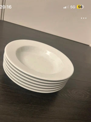 6 vita djupa tallrikar i porslin - Säljer ett set med sex stycken vita djupa tallrikar i klassisk rund form. Perfekta för soppa, pasta eller sallad. Tallrikarna är tillverkade i porslin och har en stilren, enkel design utan mönster eller dekorationer. Jag säljer 1 st tallrik för 30 kr, 2 st tallrikar för 50 kr och om man vill köpa alla så säljer jag dom för 230 kr OBS frakt betalar man själv