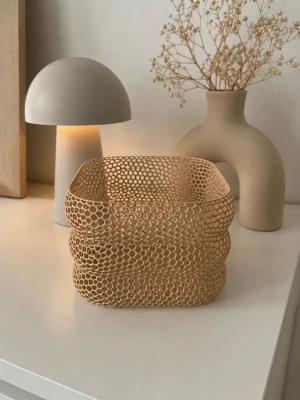 Beige nätkorg i modern design - Säljer en beige nätkorg med fyrkantig form och vågiga kanter. Korgen är tillverkad i ett lätt plastmaterial med ett unikt hålmönster som ger en modern och stilren känsla. Perfekt som förvaringskorg eller dekoration i hemmet.