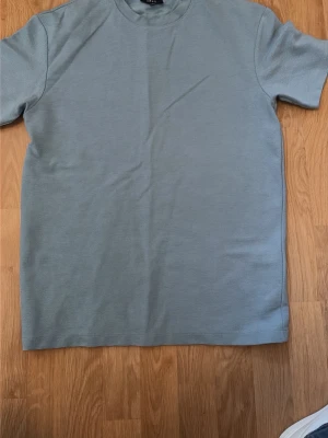 Ljusblå basic t-shirt - En stilren ljusblå t-shirt med rund hals och korta ärmar. T-shirten har en enkel och clean design utan tryck eller mönster, perfekt för en avslappnad look. Materialet känns mjukt och bekvämt mot huden.