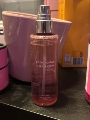 Glow Monkey Face Mist Spray - Glow Monkey face mist spray i en genomskinlig rosa plastflaska med silvrig spraypump. 100% vegansk och passar alla hudtyper. Perfekt för att fräscha upp huden under dagen och ge extra lyster.