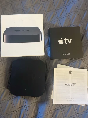 Apple TV mediaspelare svart - Apple TV mediaspelare i svart, kompakt och fyrkantig design med rundade hörn. Tillverkad i plast och levereras med originalkartong samt manualer och installationsguide. Perfekt för att streama filmer, serier och musik direkt till din TV.