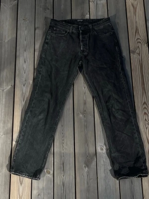 Jack & Jones Chris - Snygga svarta jeans med rak passform och klassisk femficksdesign. Jeansen har en lätt tvättad look som ger en cool vintagekänsla. Perfekta för dig som gillar en avslappnad och tidlös stil. Materialet är denim i bomull. Stl 31/34