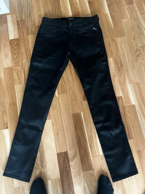 Svarta jeans från replay - Säljer ett par svarta skinny jeans från replay  med klassisk femficksdesign och normal midja. Jeansen har smal passform och är tillverkade i stretchigt material för extra komfort. Perfekta för en stilren och enkel look.